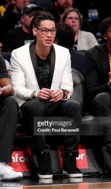 Jeremy Lin of the Brooklyn Nets, who is out for the season after having knee surgery, watches the game from the team bench with teammates during an...