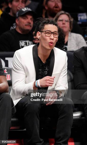 Jeremy Lin of the Brooklyn Nets, who is out for the season after having knee surgery, reacts to a teammate taking and missing a shot as he watches...