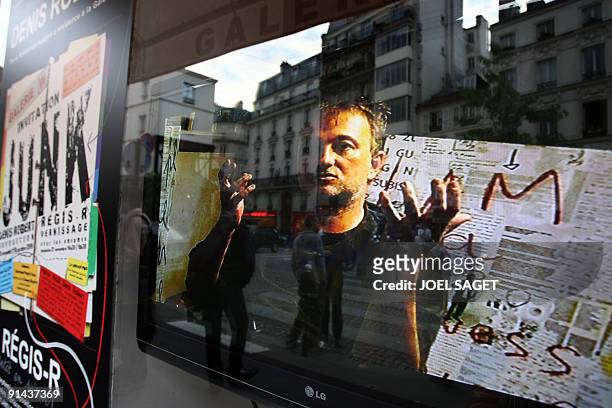 French journalist Denis Robert is pictured on a screen, on September 24 at a Paris gallery, during an exhibition featuring more than 70 paintings...
