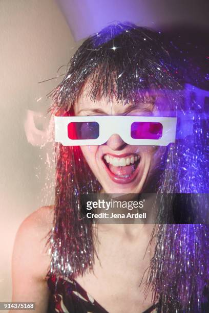 90s woman laughing wearing 3-d glasses and silver wig at new years eve house party - 90 years stockfoto's en -beelden