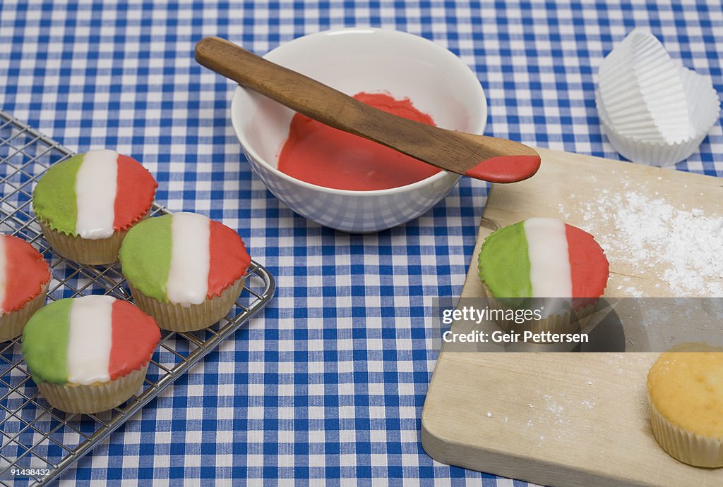 Cupcakes decorated with flags on baking tray 