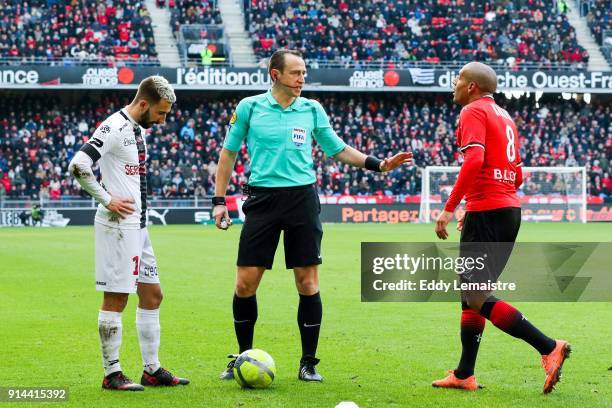 The referee Ruddy Buquet between Nicolas Benezet of Guingamp and Wahbi Khazri of Rennes during the Ligue 1 match between Rennes and EA Guingamp at...