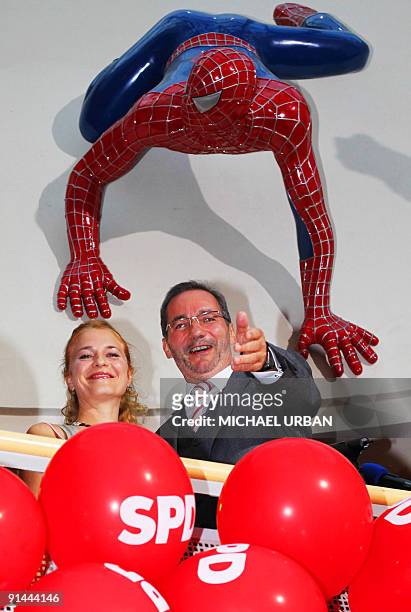 Brandenburg State Premier Matthias Platzeck and his wife Jeanette Jesorka stand under a spiderman figure after parliamentary elections and regional...