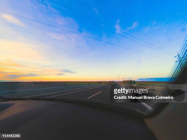 driving at sunset - kilometer stockfoto's en -beelden