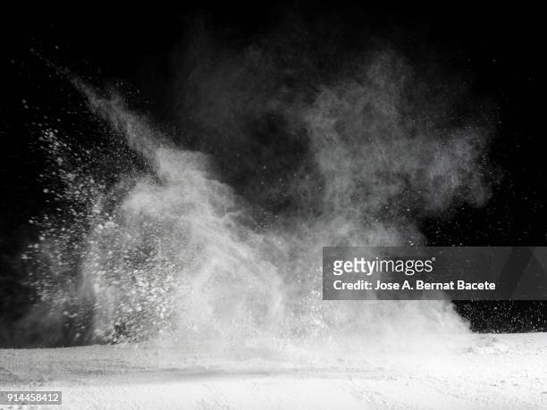 explosion by an impact of a cloud of particles of powder  of color white and a black background - fundo preto imagens e fotografias de stock