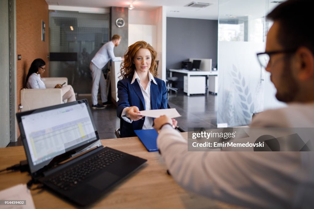Young businesswoman filling in application form at job interview