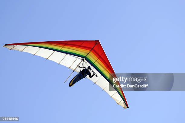 a person hang gliding on a clear day - zweefvliegtuig stockfoto's en -beelden