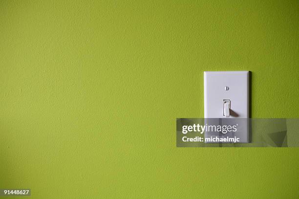 light switch in front of green background - switch stock pictures, royalty-free photos & images