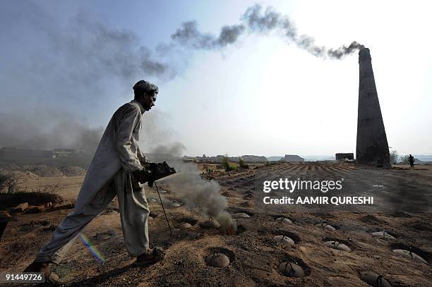 Pakistan-social-labour-poverty,FEATURE by Khurram Shahzad This photo taken on September 25, 2009 shows a Pakistani labourer working at a brick kiln...