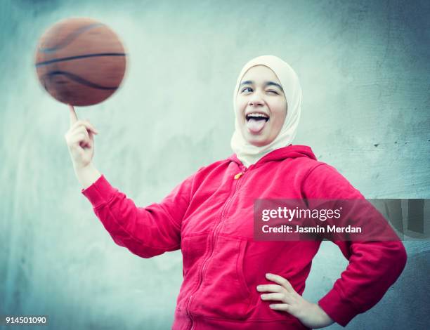 muslim girl playing basketball in city - teenage girl basketball stock pictures, royalty-free photos & images