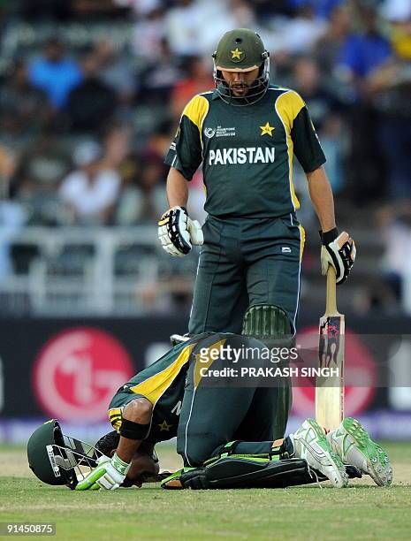 Pakistan's Omer Akmal touches the ground after his half century as Shahid Afrid looks on during the ICC Champions Trophy's second semi final match...