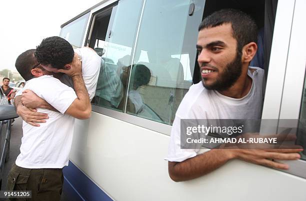 Relative hugs a released prisoner sitting in a mini bus on September 28 in Baghdad after being freed from jail. Thirty two men were released today...