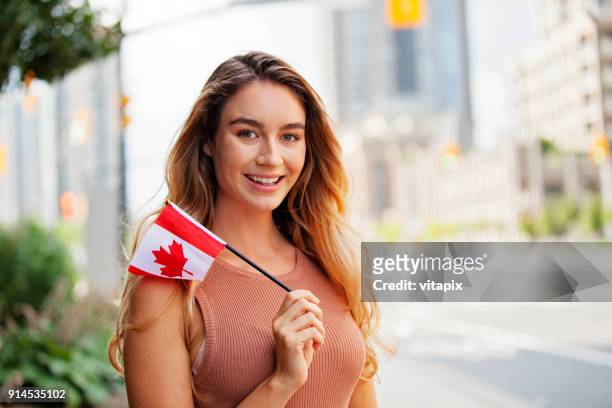 young woman with a canadian flag outside portrait - canada day people stock pictures, royalty-free photos & images