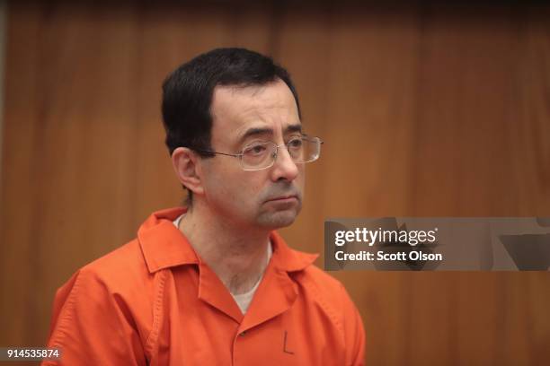 Larry Nassar stands as he is sentenced by Judge Janice Cunningham for three counts of criminal sexual assault in Eaton County Circuit Court on...