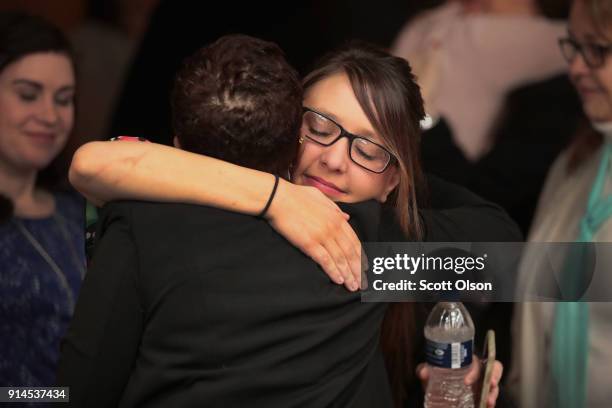 Victims and their family members embrace following the sentencing hearing for Larry Nassar in Eaton County Circuit Court on February 5, 2018 in...