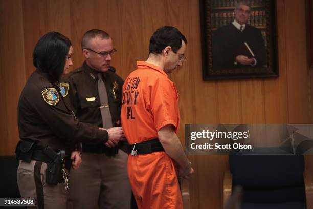 Larry Nassar is led from the courtroom after being sentenced by Judge Janice Cunningham to 40 to 125 years in prison for three counts of criminal...