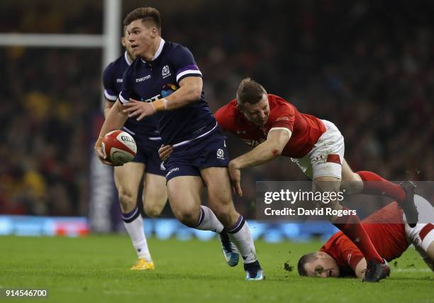 Huw Jones of Scotland breaks with the ball as Hadleigh Parkes tackles during the NatWest Six Nations match between Wales and Scotland at the...