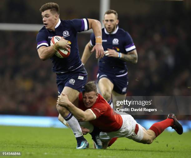 Huw Jones of Scotland breaks with the ball as Hadleigh Parkes tackles during the NatWest Six Nations match between Wales and Scotland at the...