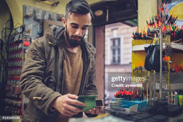 young man shopping new fishing equipment - barbed hook stock pictures, royalty-free photos & images