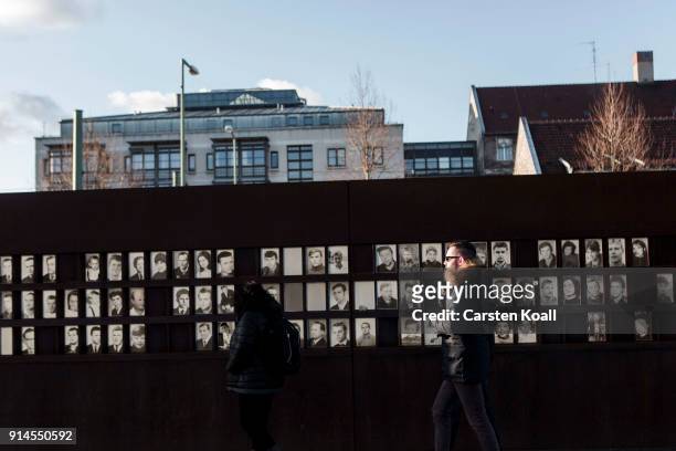 Visitors look at pictures of people who died at the border at the Berlin Wall memorial at Bernauer Strasse on February 5, 2018 in Berlin, Germany....