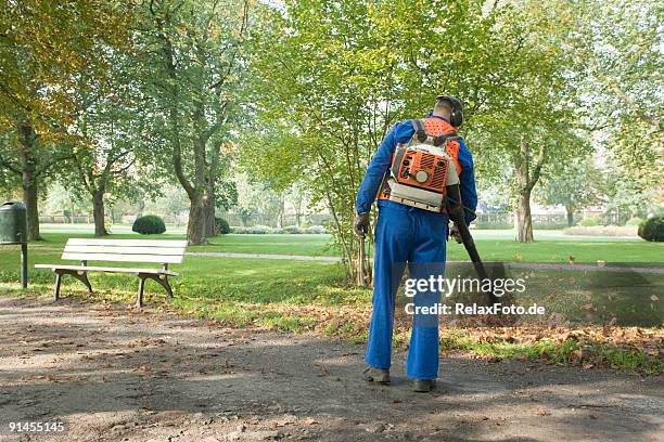 homem vestindo blue macacões removendo as folhas de trilha do parque - street sweeper - fotografias e filmes do acervo