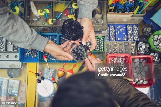 comprar equipo de pesca en una tienda joven - cebo fotografías e imágenes de stock