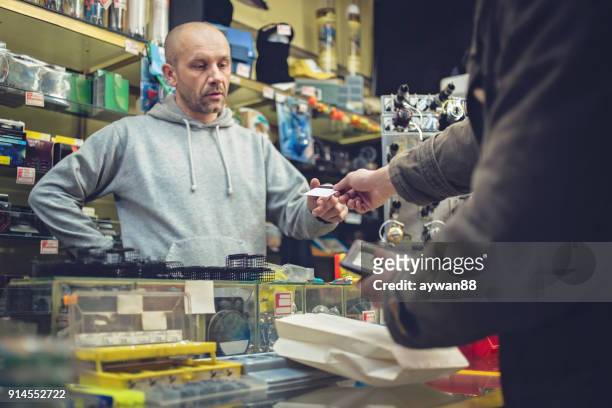 young fisherman buying fishing equipment - barbed hook stock pictures, royalty-free photos & images