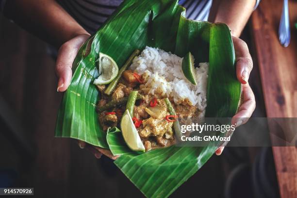 indonesische curry huhn mit reis auf bananenblatt serviert - bananenblatt stock-fotos und bilder