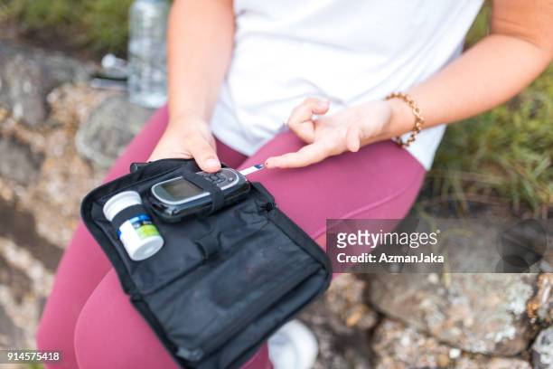 woman with diabetes measuring blood glucose after workout - blood sugar test stock pictures, royalty-free photos & images