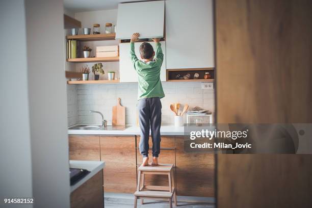 stealing cookies from the kitchen cabinet - solitude stock pictures, royalty-free photos & images