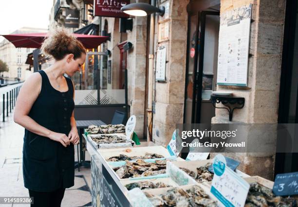 women looking at a display of seafood in bordeaux - fish market french stock pictures, royalty-free photos & images