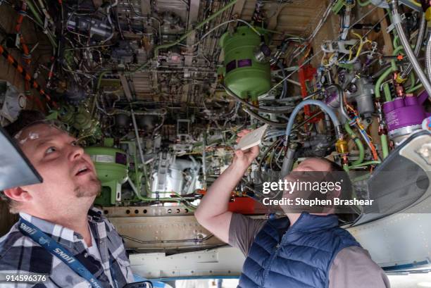 Employees check out the wheel well of the first Boeing 737 MAX 7 aircraft as it sits on the tarmac outside of the Boeing factory on February 5, 2018...