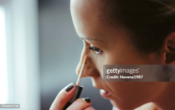 jonge vrouwen toegepast concealer onder de ogen - eye make up stockfoto's en -beelden