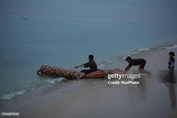 Palestinian boys on their boat is made of plastic near to the beach in Gaza City February 5, 2018.