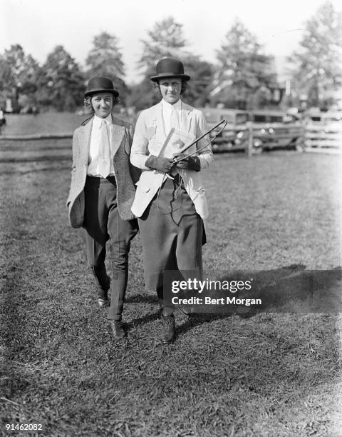 American sisters Alice and Nancy Whitney , daughters of financier Richard Whitney and both dressed in riding clothes, walk together at the Far Hills...