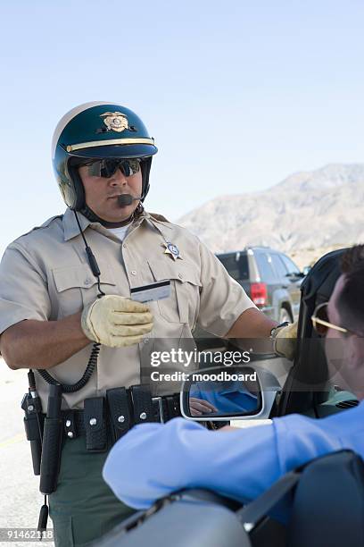 police officer checking driver's id - police scrutiny stock pictures, royalty-free photos & images