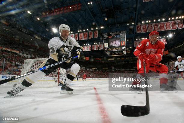 Pavel Datsyuk of the Detroit Red Wings races to the corner for the puck with Bill Guerin of the Pittsburgh Penguins during a NHL pre-season game at...