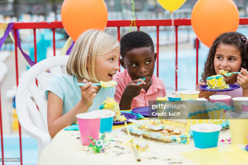 Niños en una fiesta de cumpleaños comiendo pastel