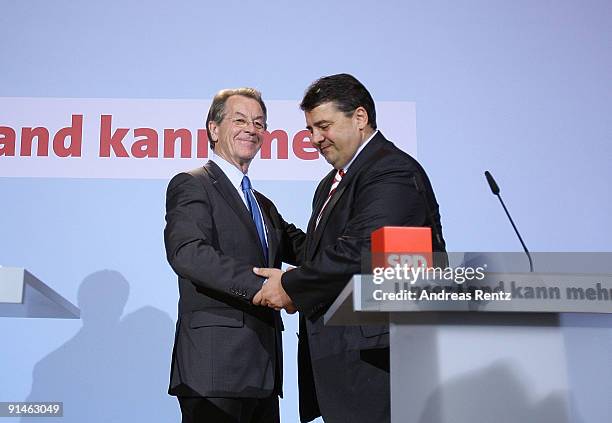 Outgoing Chairman Franz Muentefering of the German Social Democrats and Sigmar Gabriel shake hands during a press conference following a meeting of...