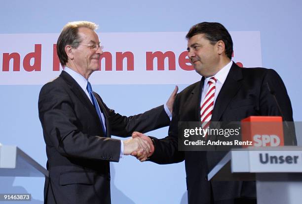 Outgoing Chairman Franz Muentefering of the German Social Democrats and Sigmar Gabriel shake hands during a press conference following a meeting of...