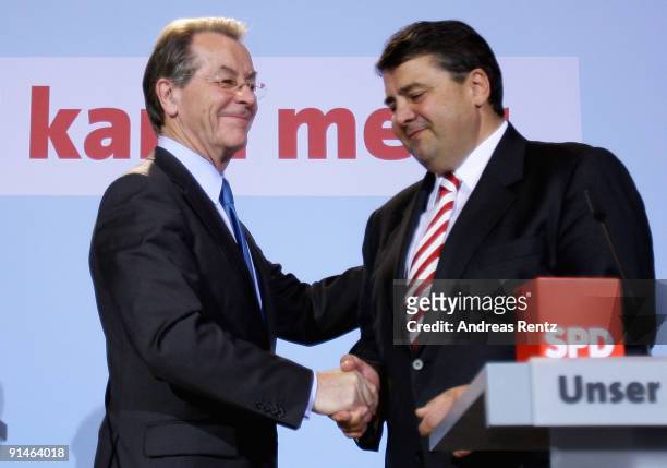 Outgoing Chairman Franz Muentefering of the German Social Democrats and Sigmar Gabriel shake hands during a press conference following a meeting of...