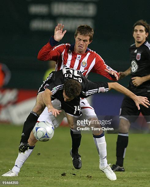 Ben Olsen of D.C. United is hit from behind by Justin Braun of Chivas USA during an MLS match at RFK Stadium on October 3, 2009 in Washington, DC....