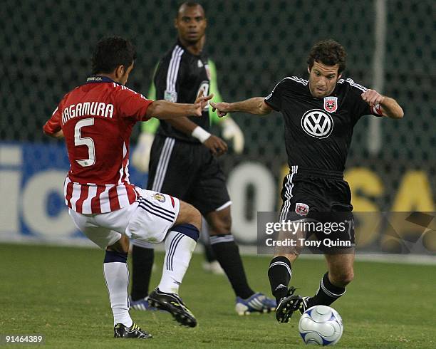 Ben Olsen of D.C. United turns the ball away from Paulo Nagamura of Chivas USA during an MLS match at RFK Stadium on October 3, 2009 in Washington,...