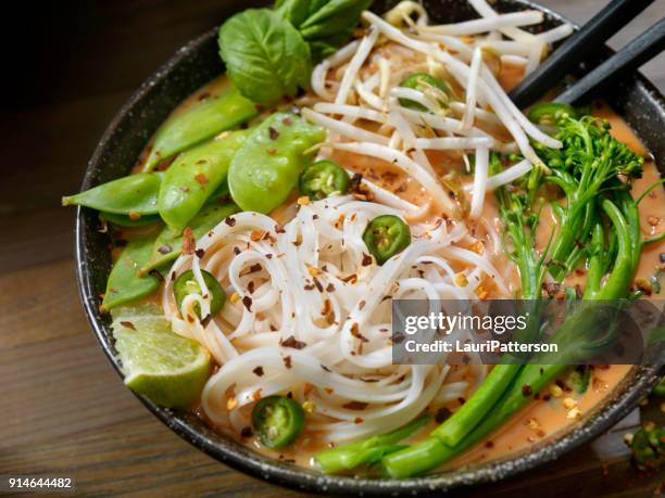 red curry noodle soup with broccolini, bean sprouts and fresh basil, - curry soup stock pictures, royalty-free photos & images
