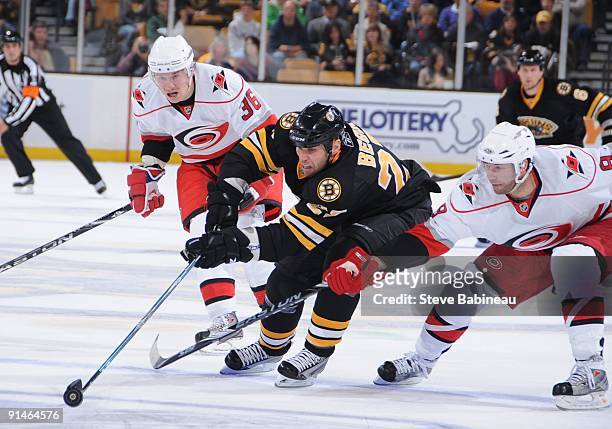 Steve Begin of the Boston Bruins skates after the puck against Jussi Jokinen and Matt Cullen of the Carolina Hurricanes at the TD Banknorth Garden on...