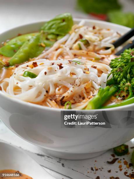 red curry noodle soup with broccolini, bean sprouts and fresh basil, - curry soup stock pictures, royalty-free photos & images
