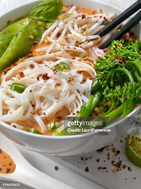 red curry noodle soup with broccolini, bean sprouts and fresh basil, - curry soup stock pictures, royalty-free photos & images