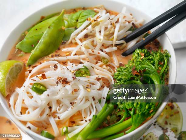 red curry noodle soup with broccolini, bean sprouts and fresh basil, - curry soup stock pictures, royalty-free photos & images