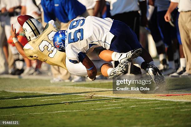 Linebacker Greg Johnson of the Memphis Tigers tackles half back Billy Giovanetti of the Central Florida Knights at Bright House Networks Stadium on...