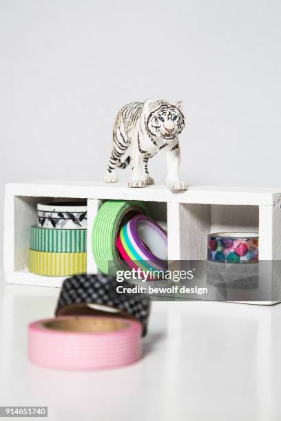 plastic tiger on box with masking tapes - buero stock pictures, royalty-free photos & images